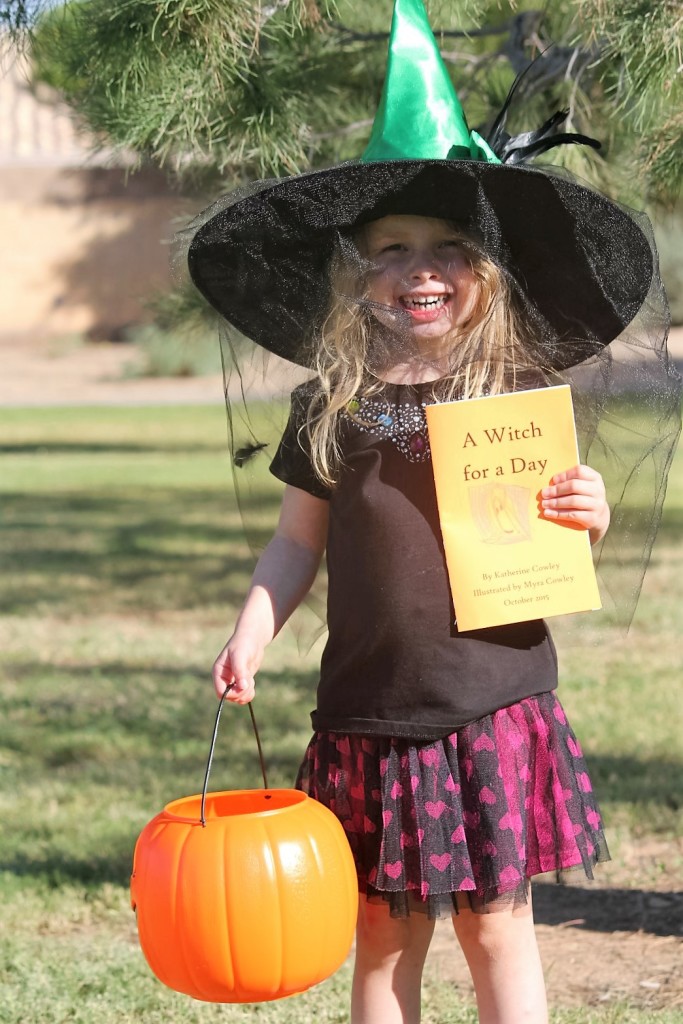 Myra holding her illustrated copy of A Witch for a Day